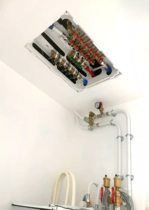 Intérieur technique avec installation de plomberie et chauffage visible